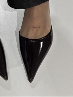 a woman's foot with a small tattoo on it