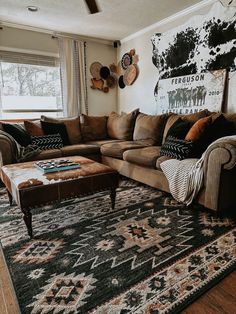 a living room with couches and rugs in front of a large painting on the wall