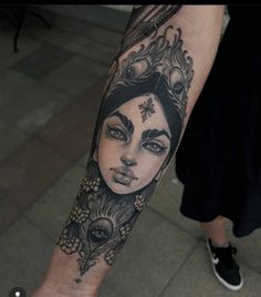 a woman's arm with a tattoo on it and an ornate headdress