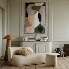 a living room filled with furniture and a painting on the wall