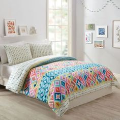 a bed room with a neatly made bed and pictures hanging on the wall above it