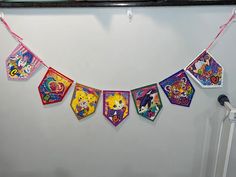 there is a banner hanging on the wall with cartoon characters and other things in it