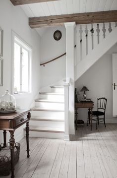 an image of a white staircase with glasses on the floor and in front of it