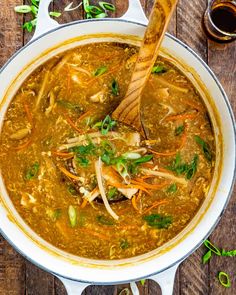 a large pot filled with soup on top of a wooden table