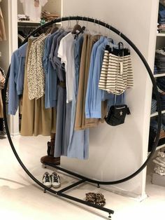 a rack with clothes and shoes on it in a room next to a closet full of other items