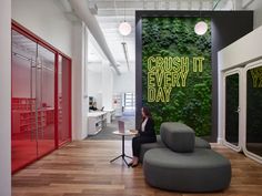 a woman sitting on a chair in front of a green wall with the words crush it every day