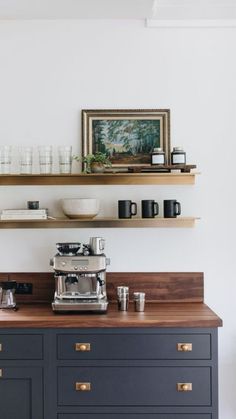 a coffee maker on top of a counter in a kitchen with wooden shelves above it