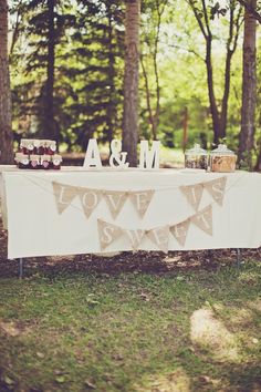 the table is set up in the middle of the woods for an outdoor wedding reception