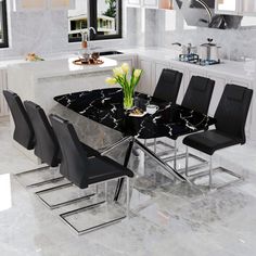 a marble dining table surrounded by black chairs