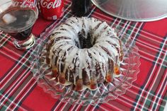 a bundt cake sitting on top of a glass plate next to a coke bottle