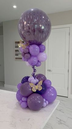 purple balloons are stacked on top of each other in the middle of a kitchen counter