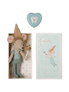 a toy mouse in a box next to a greeting card with a tooth fairy on it