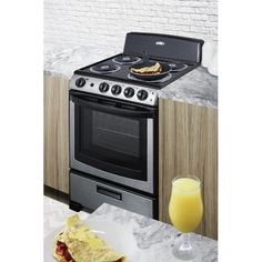 a silver stove top oven sitting inside of a kitchen next to a plate of food