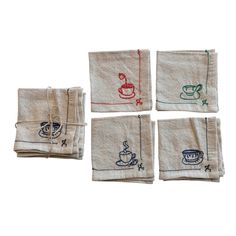 four napkins with different designs on them, one has a cup and saucer