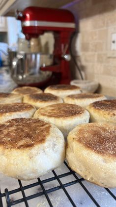 freshly made english muffins are cooling on the rack in the kitchen, ready to be baked