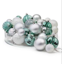 a glass bowl filled with green and white ornaments