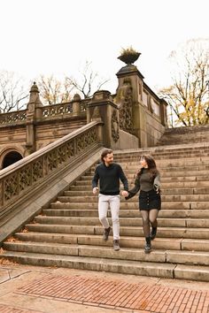 two people walking up some steps holding hands