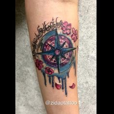 a tattoo on the leg of a person with a compass and flowers