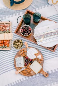 an assortment of cheeses, crackers and other foods on a wooden platter