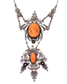 "Amazing late Victorian coral cameo and gilded silver filigree necklace. Very elaborate hand-wrought design featuring a two layered pendant that lends a charming movement to the piece. The focal point is the high relief coral cameo of a classical goddess. The lower panel features a matching coral cabochon. The swirling filigree is studded with tiny gilded silver beads. Delicate milgraining throughout adds a subtle texture. The chain is very simple and the clasp is original and works perfectly. I Formal Orange Cabochon Necklace, Elegant Carved Orange Jewelry, Elegant Orange Carved Jewelry, Ornate Medallion Necklace With Cabochon, Ornate Medallion Cabochon Necklace, Oval Filigree Necklace In Art Nouveau Style, Art Nouveau Oval Filigree Necklace, Ornate Cameo Necklaces For Formal Occasions, Ornate Cameo Necklace For Formal Occasions