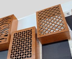 three wooden boxes sitting on top of a table next to each other with holes in them