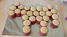 cupcakes are arranged in the shape of the letter e on a sheet of tin foil