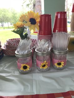 four mason jars with sunflowers in them sitting on a table