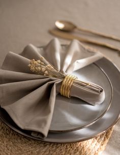 the napkins are folded on top of the plate with silverware next to it