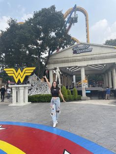 a woman standing in front of a building with wonderworld on it's side