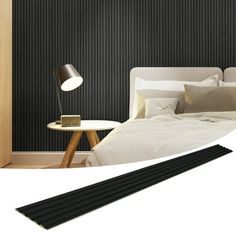 a bedroom with black and white striped wallpaper next to a lamp on a table