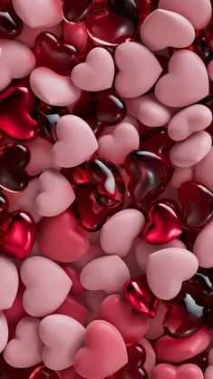 many pink and red hearts are scattered together