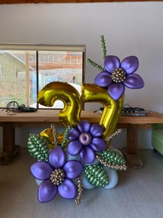 the balloon flowers are in front of the number five balloon bouquet on the dining room table