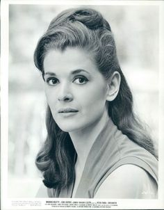 an old black and white photo of a woman with long hair wearing a turtle neck sweater