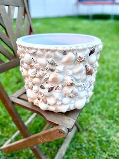 a planter sitting on top of a wooden chair in the grass next to a lawn