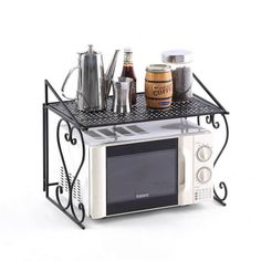 a microwave oven sitting on top of a metal shelf with spices and condiments