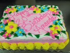 a pink and yellow birthday cake with flowers on it