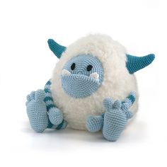 a crocheted blue and white stuffed animal with two hands on it's face