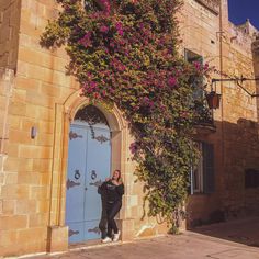 Woman leaning against the threshold of a door with flowers in the town of midna in malta royalty free stock images Door With Flowers, Architecture Facade, In The Town, Malta, Royalty Free