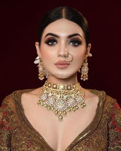 a woman wearing gold jewelry and nose ring