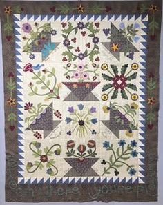 a quilted wall hanging with flowers on it