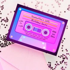 an envelope with a pink and purple cassette label on it, sitting next to some stars