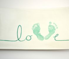 a towel with the word love written on it and two feet imprinted in green ink