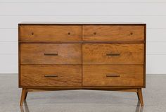 a wooden dresser sitting on top of a cement floor