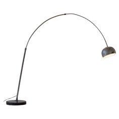 a floor lamp that is on top of a table next to a white wall with a black base