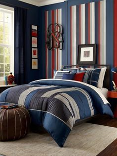 a bed room with a neatly made bed and striped walls