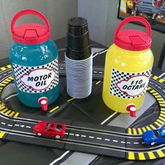 three plastic bottles sitting on top of a toy track