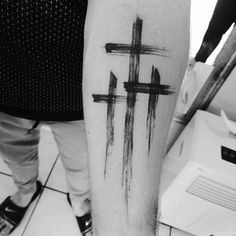 a person with a cross tattoo on their arm