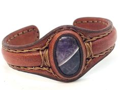 "Wide style cuff leather bracelet for men or women is the finest quality premium full grain leather chosen for its strength and durability. Leather over a copper core that can be shaped to fit. No clasp so bracelet is adjustable to fit any size wrist. Simple enough to wear every day. %100 Handcraft Called \"the spirit stone,\" Amethyst crystal helps with comprehension and associating with the everlasting presence of the spirit and starts one's own profound soul encounters. It is a perfect precio Artisan Hand Wrapped Leather Bracelet, Artisan Hand-wrapped Leather Bracelet, Spirit Stone, Amethyst Healing Properties, Leather Bracelet For Men, Handmade Boho Jewelry, Handmade Jewelry Bracelets, Leather Cuff Bracelet, Wire Wrapped Bracelet