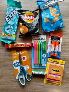 the contents of a school lunch laid out on top of a wooden table with scissors and pens