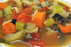 a bowl of soup with carrots, celery and other vegetables